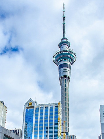 Sky Tower in Auckland, New Zealand, with surrounding city buildings.