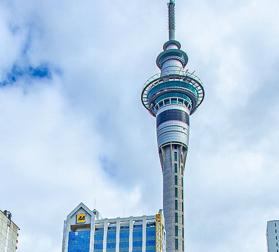 Sky Tower in Auckland, New Zealand, with surrounding city buildings.