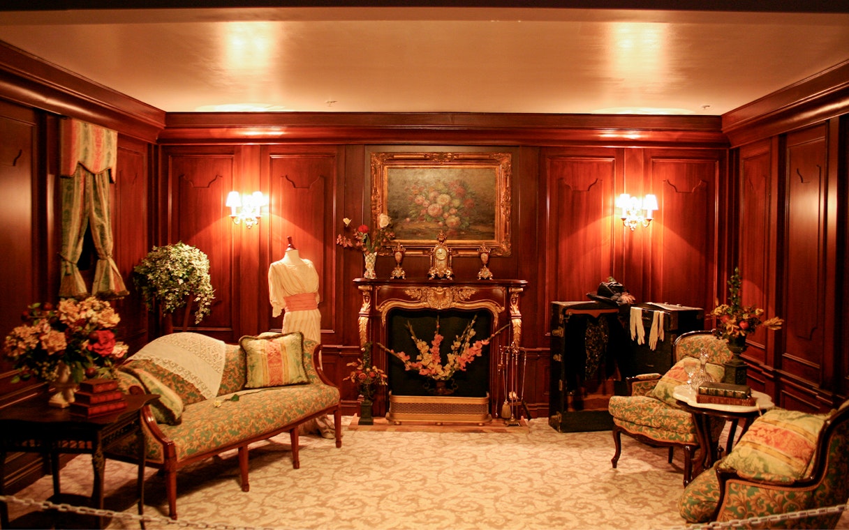 Elegant Victorian-style room with ornate fireplace and vintage furniture, part of Orlando Explorer Pass experience.