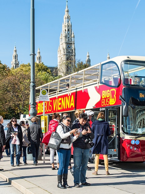 Vienna HopOn HopOff bus with tourists near Vienna City Hall.