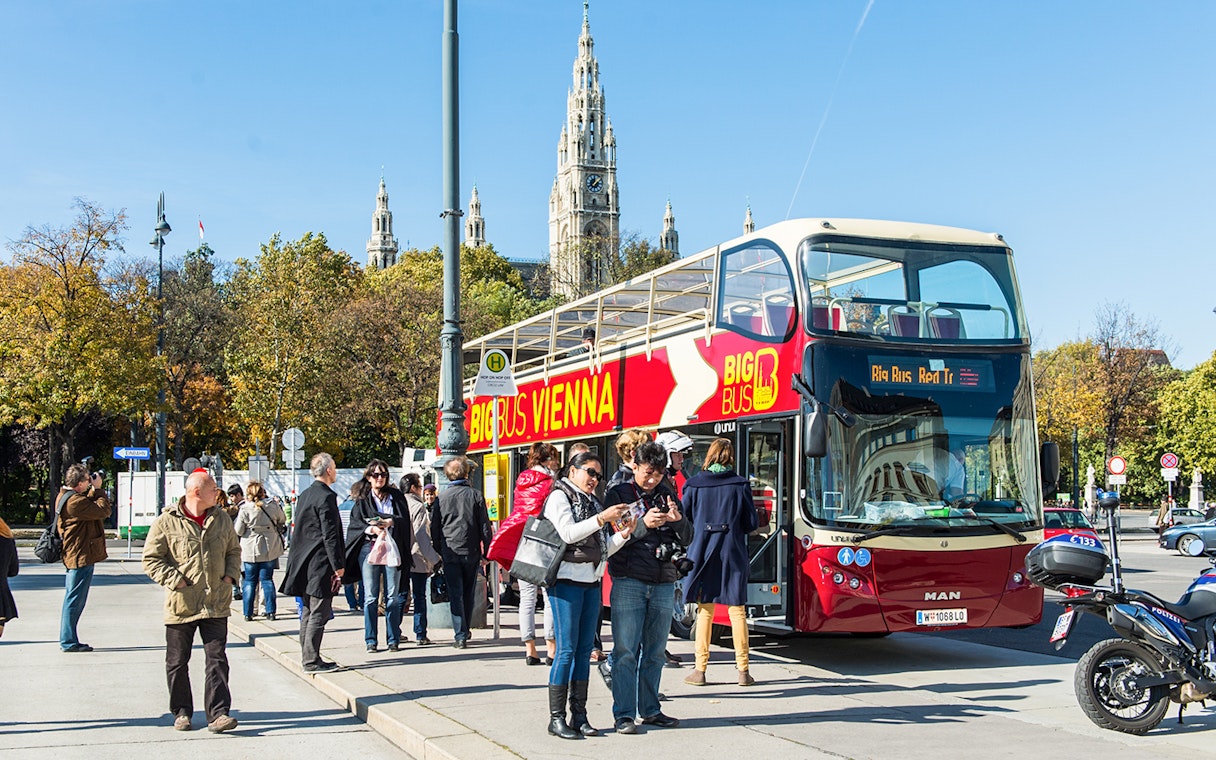 Vienna HopOn HopOff bus with tourists near Vienna City Hall.