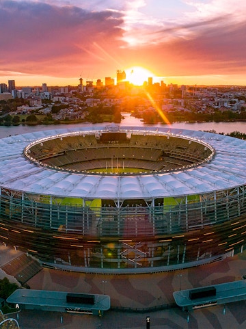 Optus Stadium in Perth at sunset with city skyline in the background.