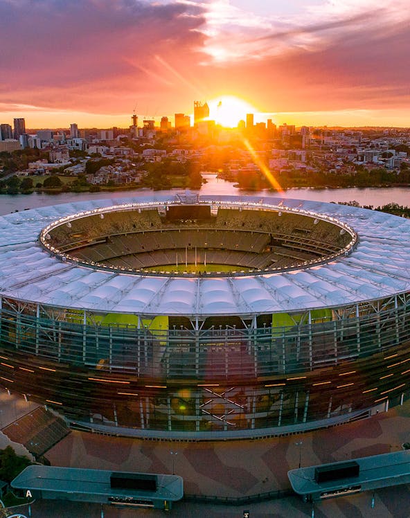 Optus Stadium in Perth at sunset with city skyline in the background.