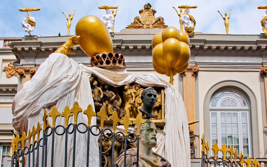Sculptures on the Dalí Museum facade featuring golden figures and artistic busts.