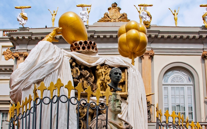 Sculptures on the Dalí Museum facade featuring golden figures and artistic busts.