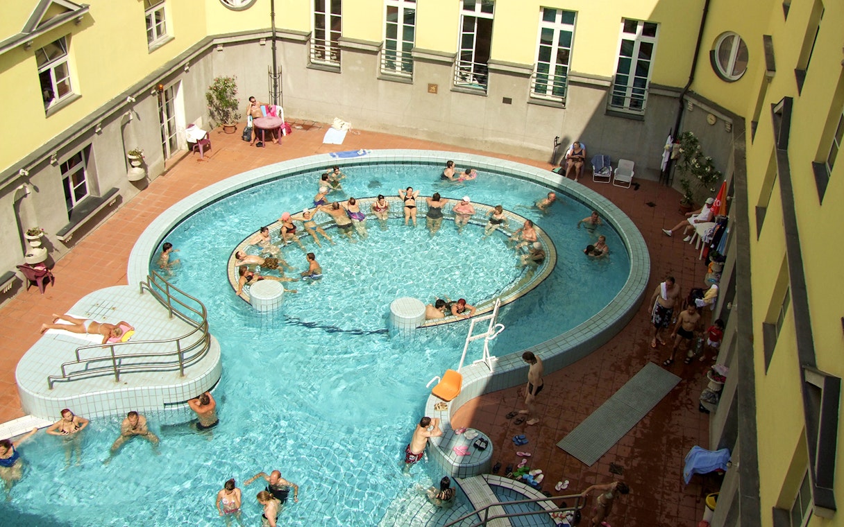 Aerial view of people enjoying the thermal pools at Lukacs Spa, Budapest.