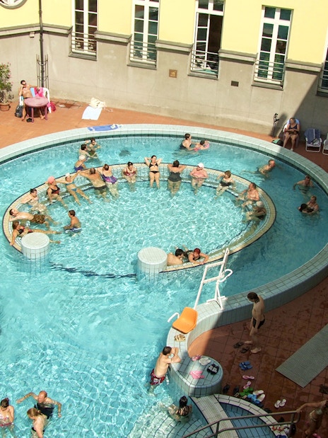 Aerial view of people enjoying the thermal pools at Lukacs Spa, Budapest.