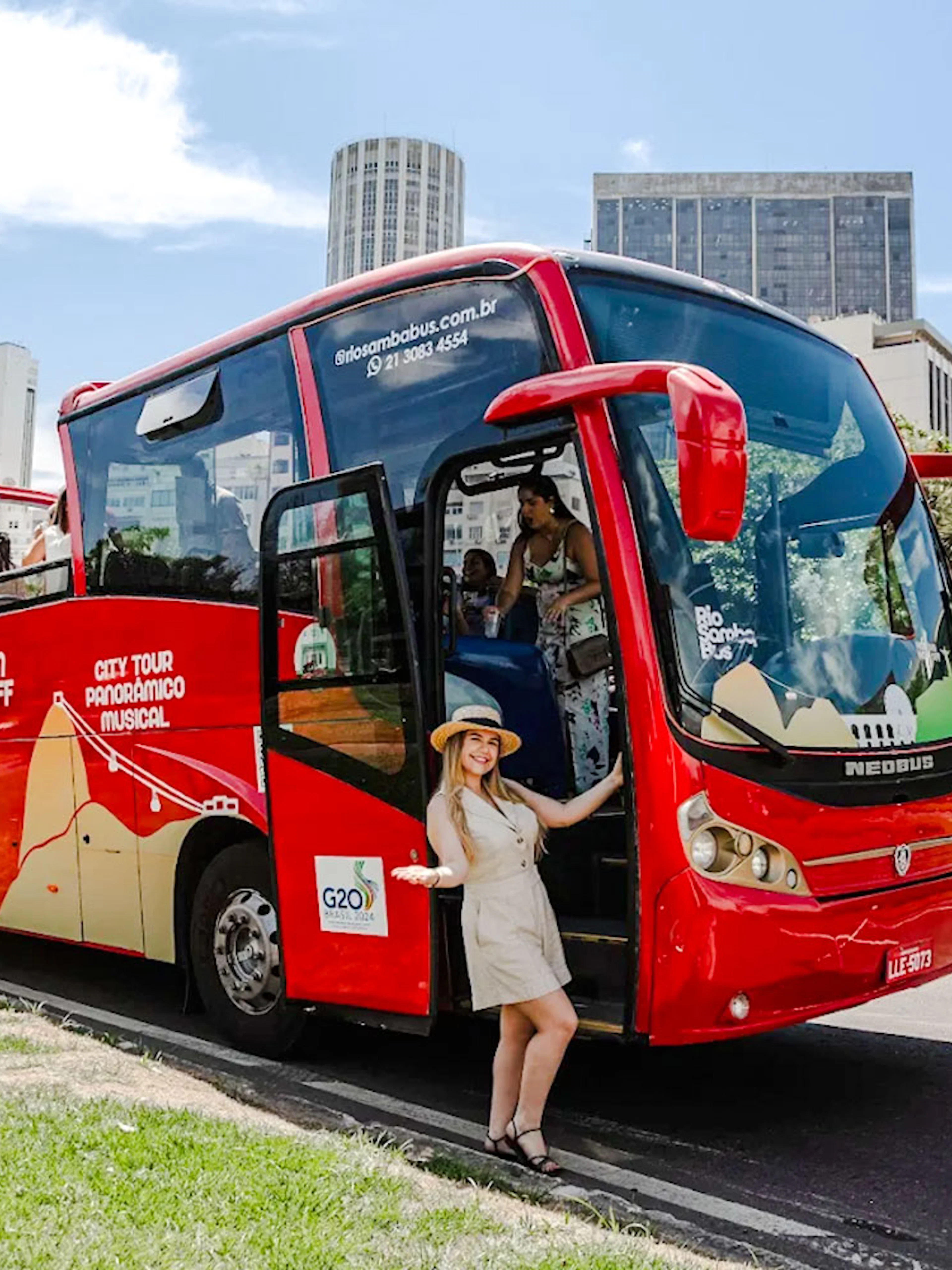 Red Rio de Janeiro hop-on hop-off bus with tourists boarding near city buildings.