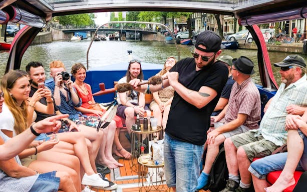Amsterdam canal cruise with people enjoying a covered heated boat, featuring a musician playing.