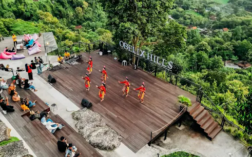 Traditional dance performance at Obelix Hills with lush greenery in the background, Dubai All Inclusive Pass.