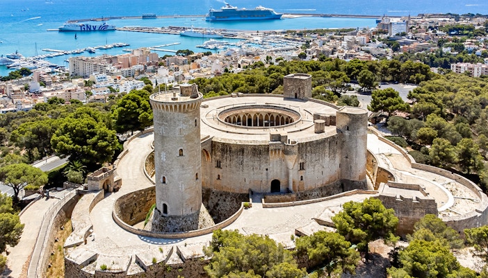 Aerial view of Castell de Bellver, circular fortress surrounded by forest in Mallorca, Spain.