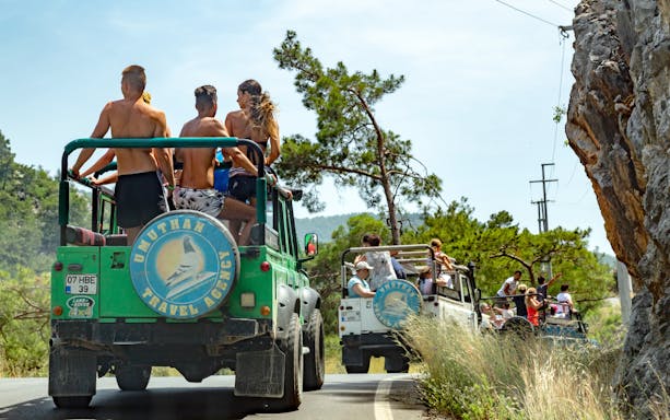 Tourists on a jeep safari in Antalya, driving through scenic mountain roads.