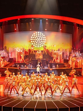 Performers in gold costumes on stage at Friedrichstadt Palast, Berlin.