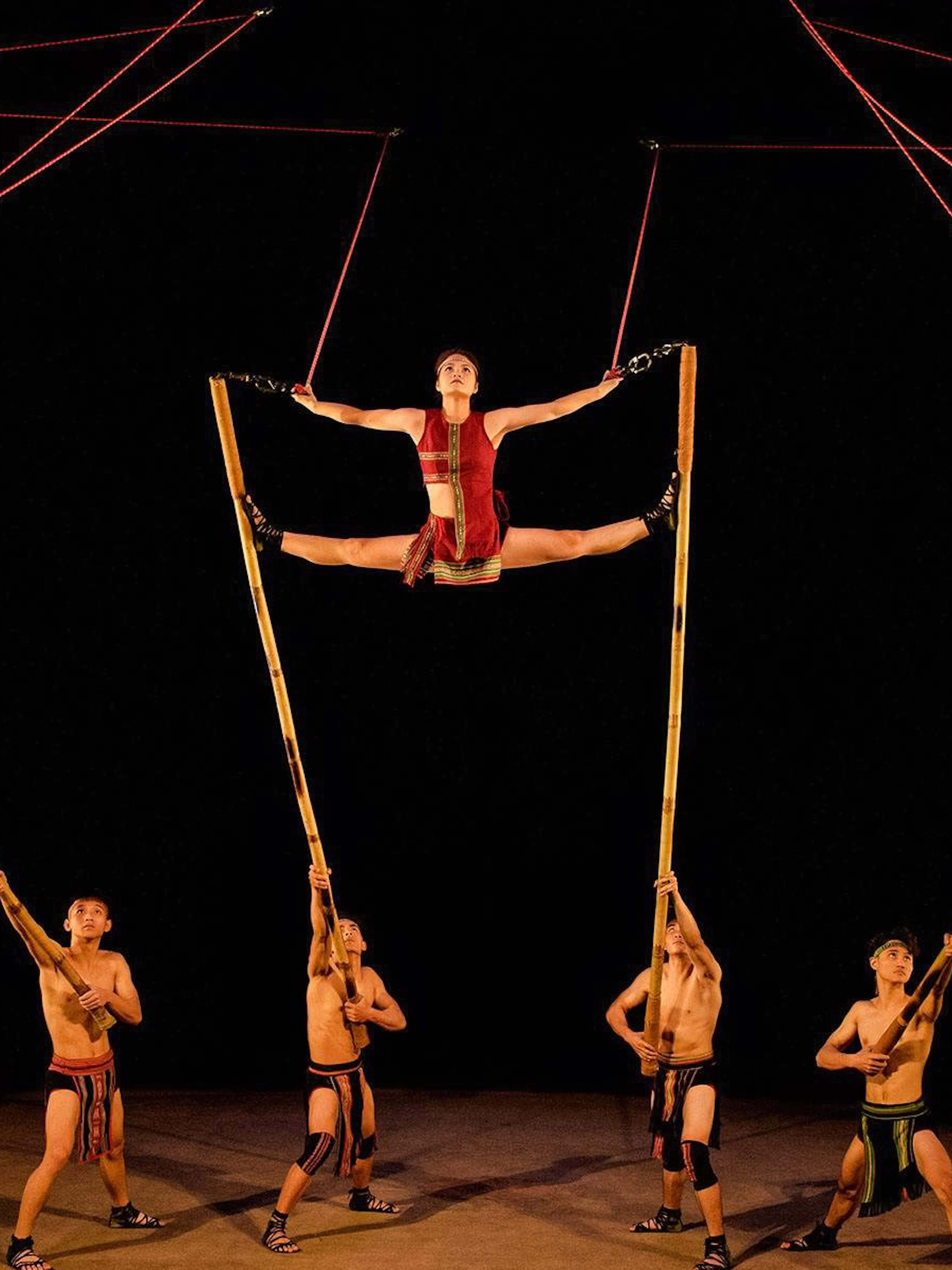 Performers using bamboo poles at Teh Dar Vietnamese Bamboo Circus under a dome.