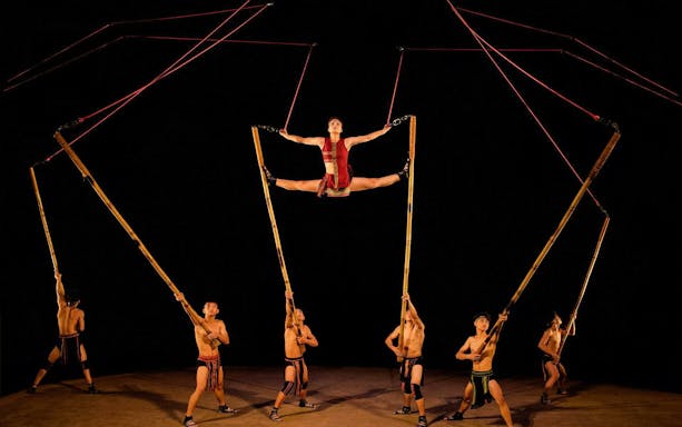 Performers using bamboo poles at Teh Dar Vietnamese Bamboo Circus under a dome.