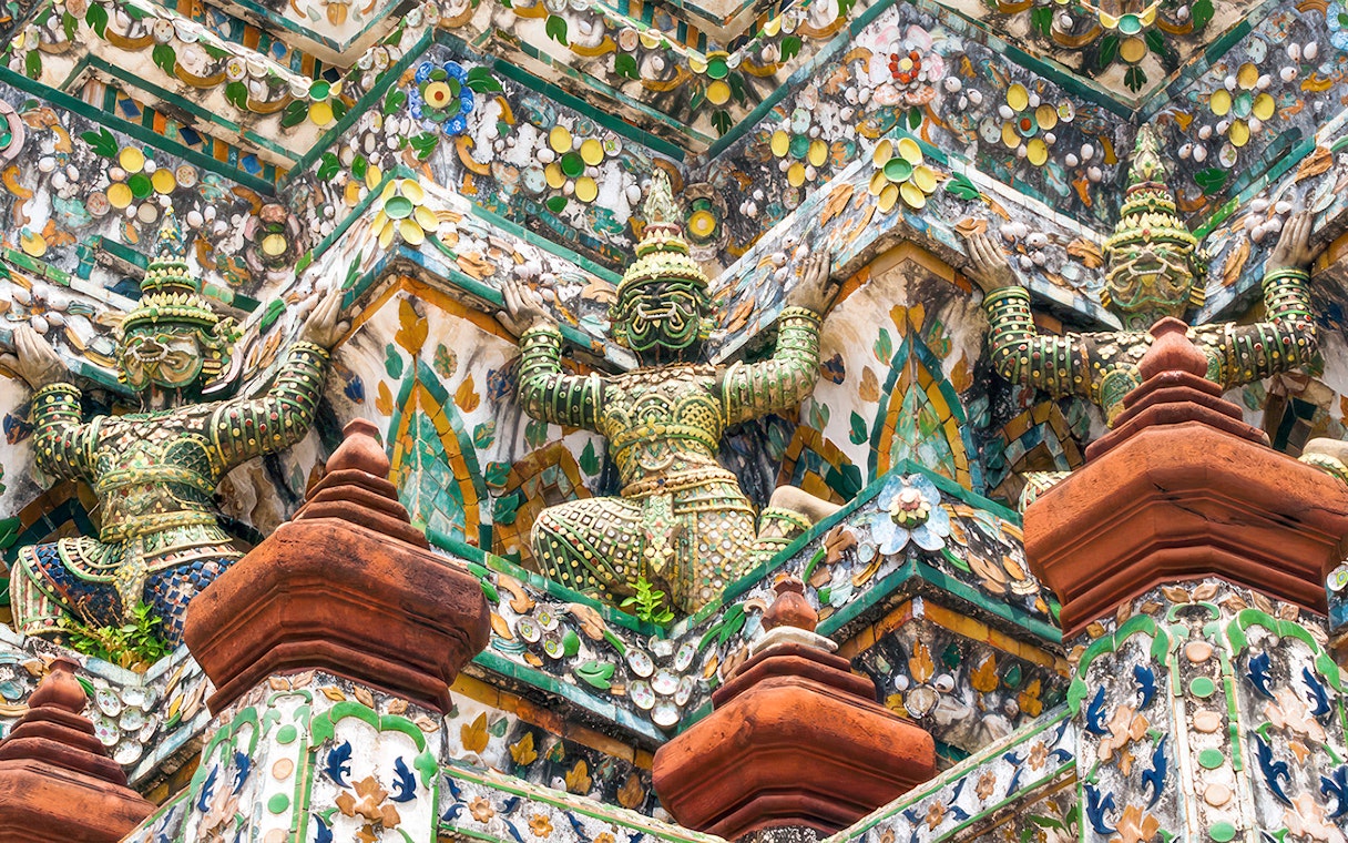 Wat Arun temple intricate sculptures on a guided walking tour in Bangkok, Thailand.