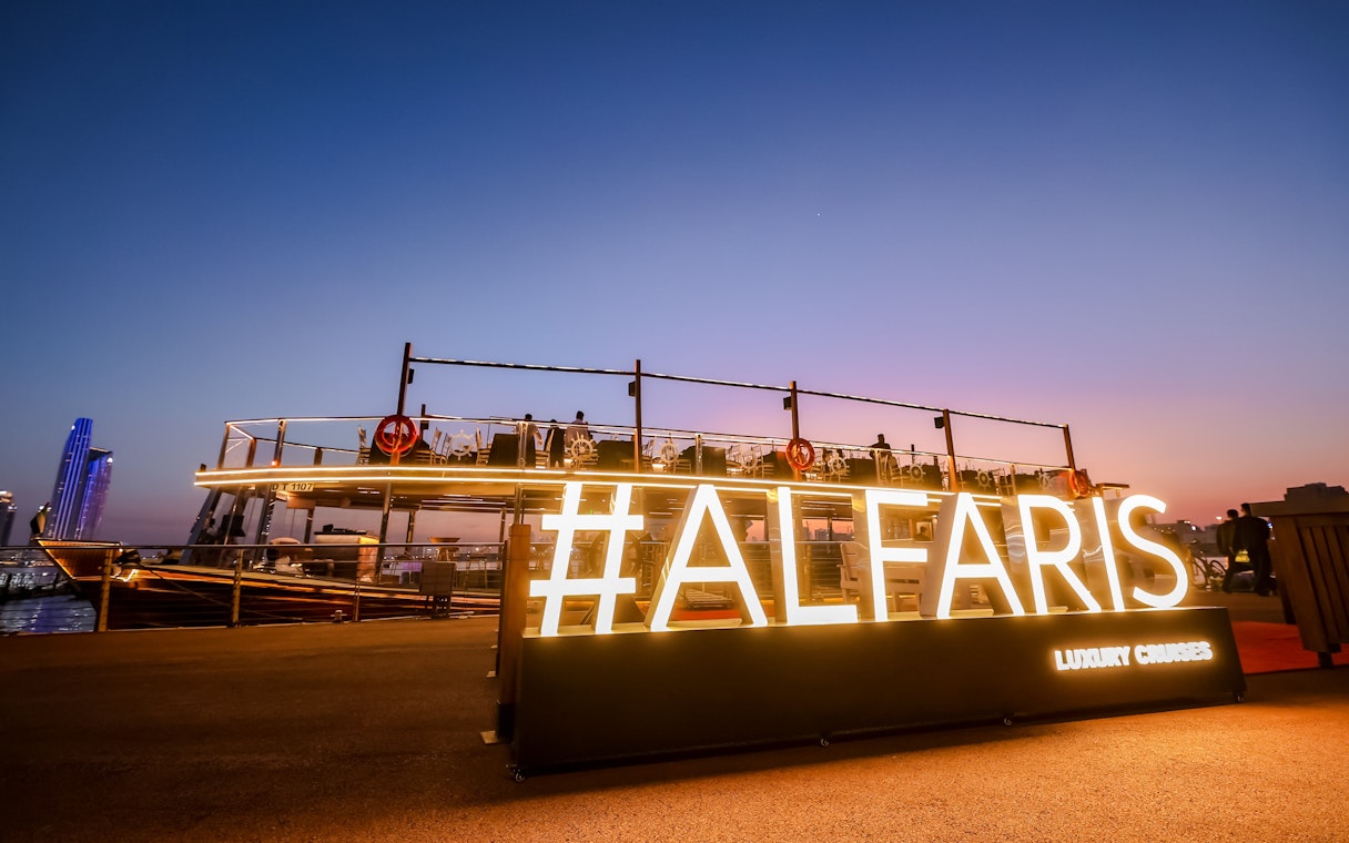 Luxury dinner cruise boat docked at Dubai Canal during sunset.