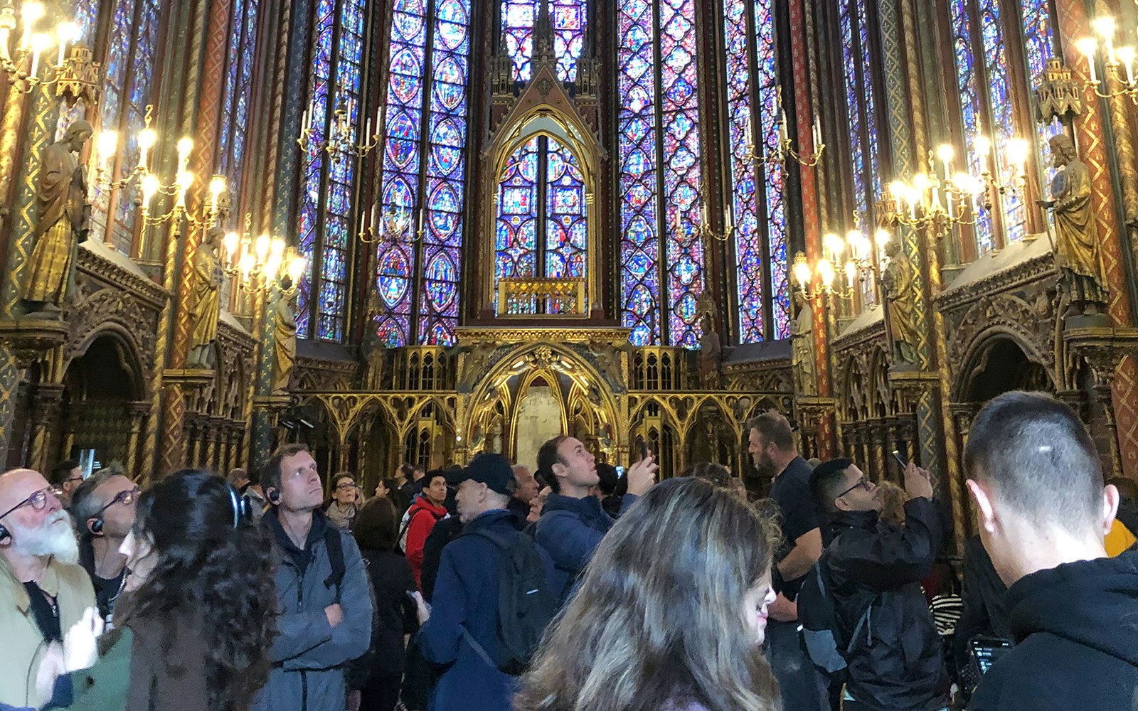 Visitors exploring the stained glass windows inside Sainte Chapelle, Paris.