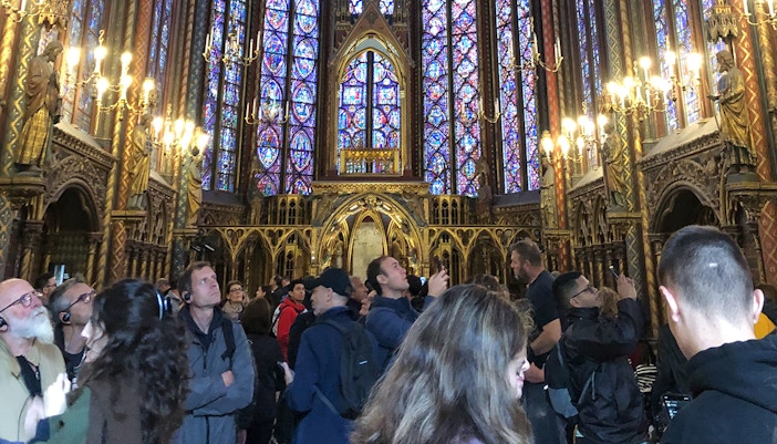 Visitors exploring the stained glass windows inside Sainte Chapelle, Paris.