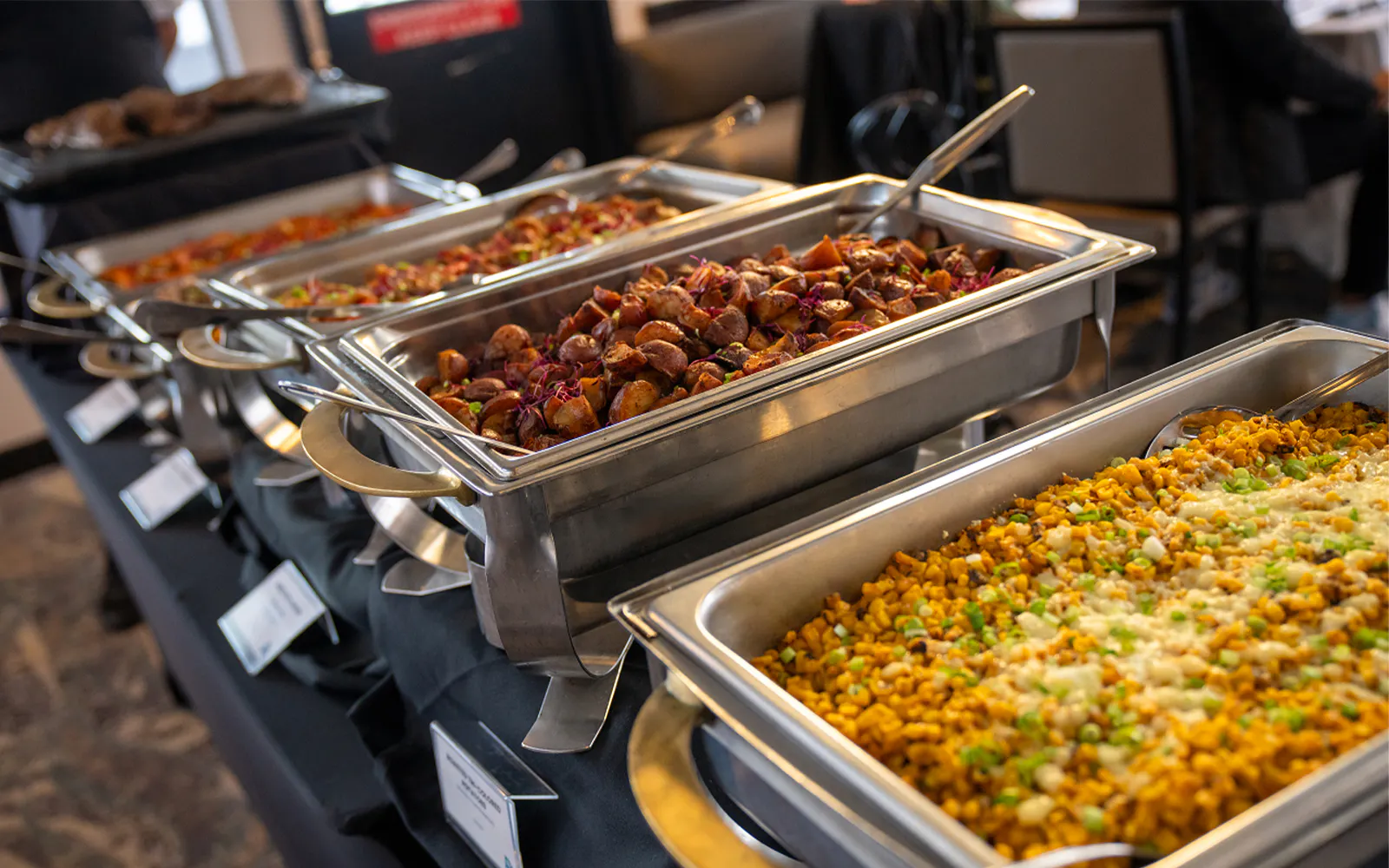 Buffet dishes on San Diego Signature Dinner Cruise with roasted potatoes and corn casserole.