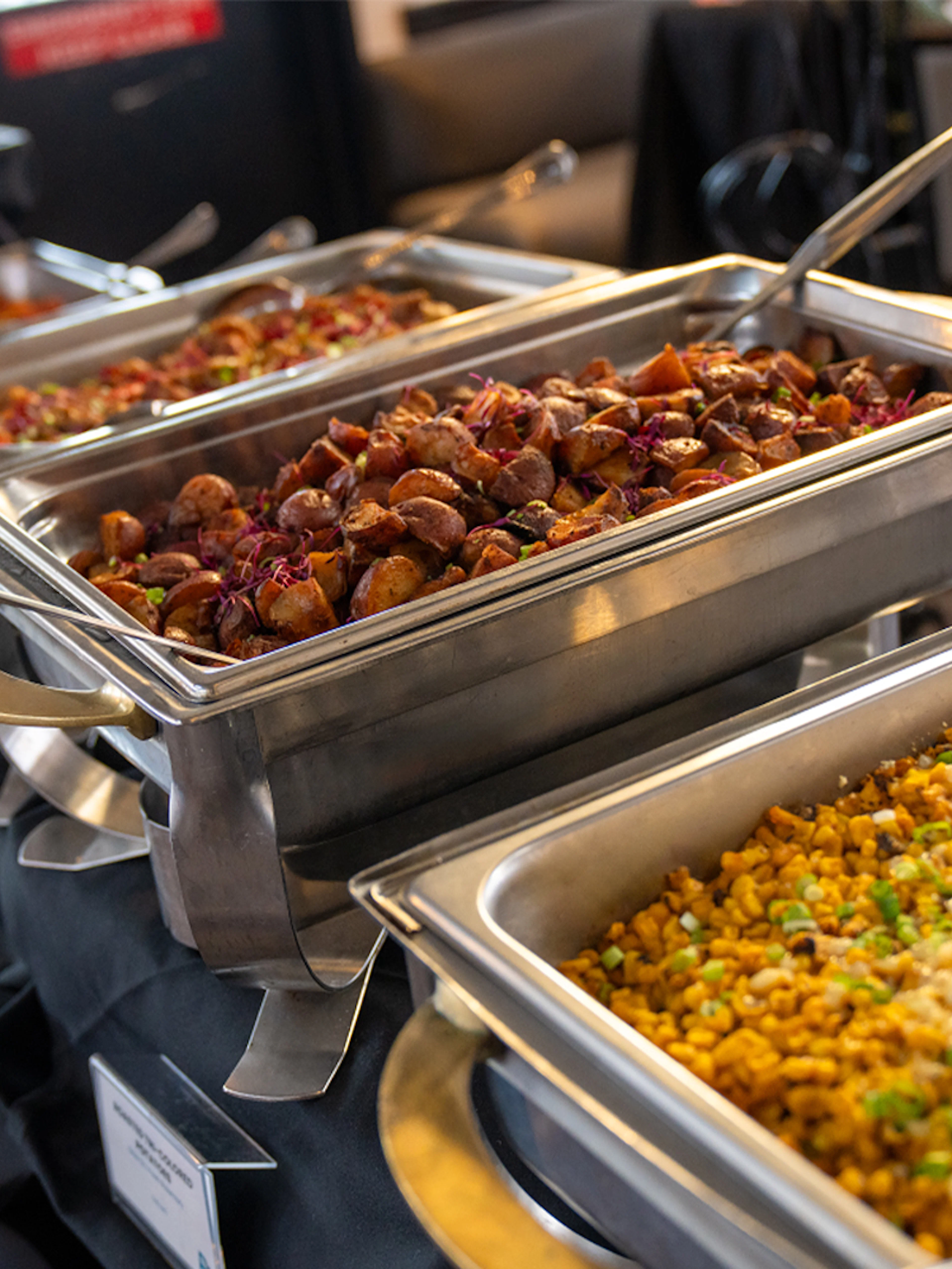 Buffet dishes on San Diego Signature Dinner Cruise with roasted potatoes and corn casserole.