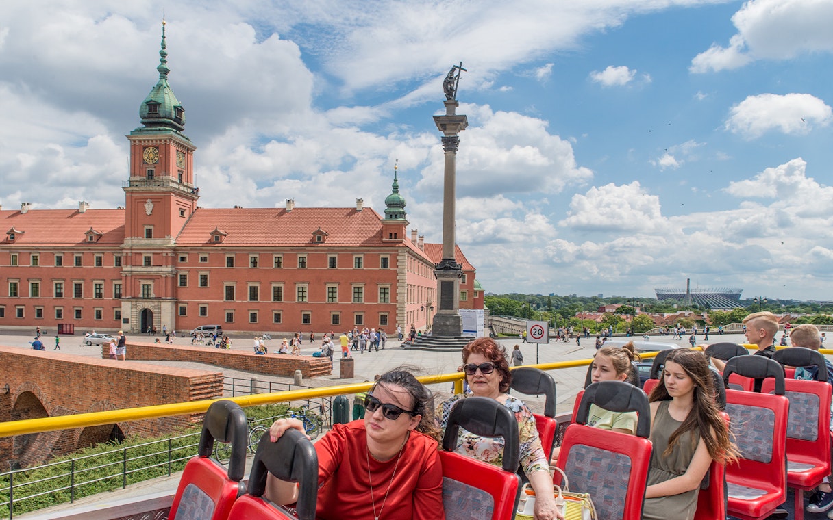 Open-top bus tour passing Warsaw's Royal Castle and Sigismund's Column.