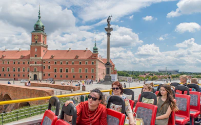 Open-top bus tour passing Warsaw's Royal Castle and Sigismund's Column.