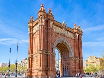Arc de Triomf in Barcelona with tourists walking and enjoying the historic landmark.