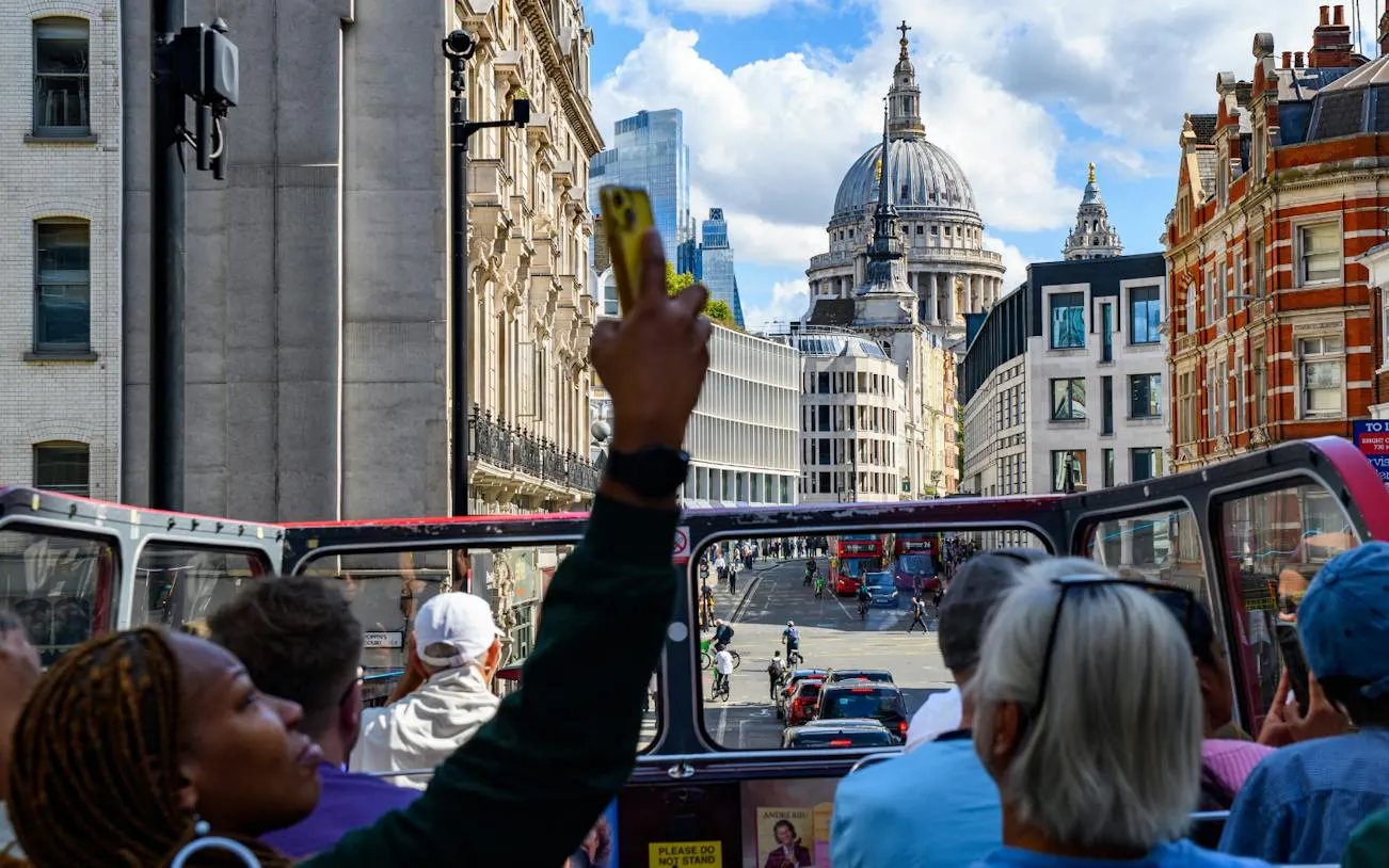 Sightseeing from a vintage open-top bus with a view of St. Paul's Cathedral, London.