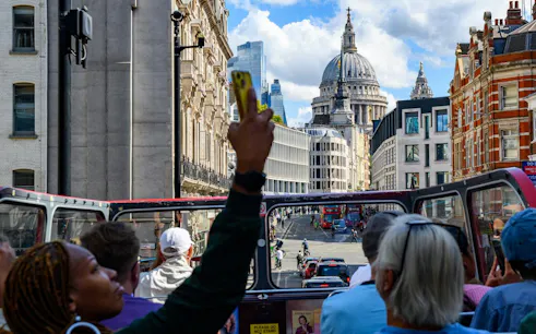 Sightseeing from a vintage open-top bus with a view of St. Paul's Cathedral, London.