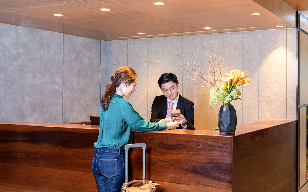 Guest checking in at Plaza Premium Lounge, Hong Kong International Airport.
