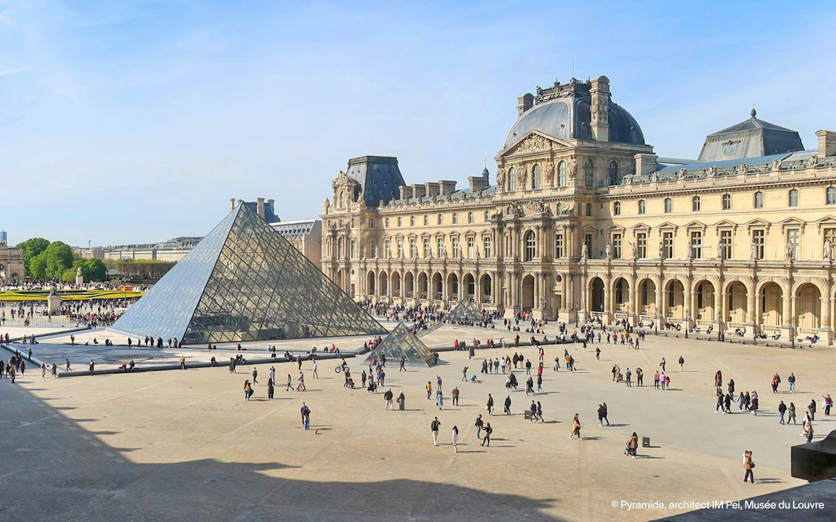 Louvre Museum courtyard with glass pyramid in Paris.