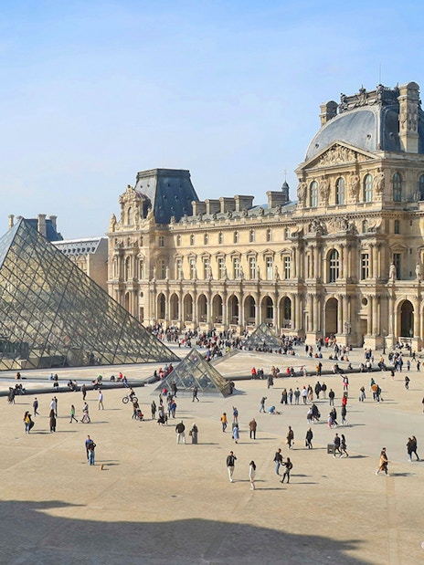 Louvre Museum courtyard with glass pyramid in Paris.