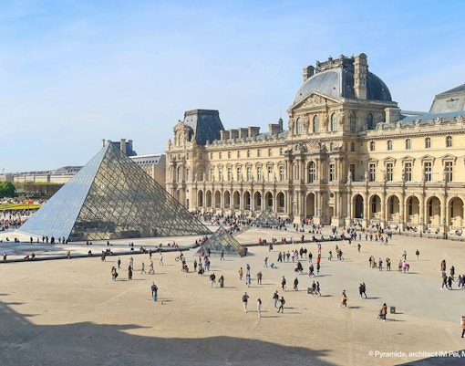 Visitors exploring art exhibits inside the Louvre Museum, Paris.