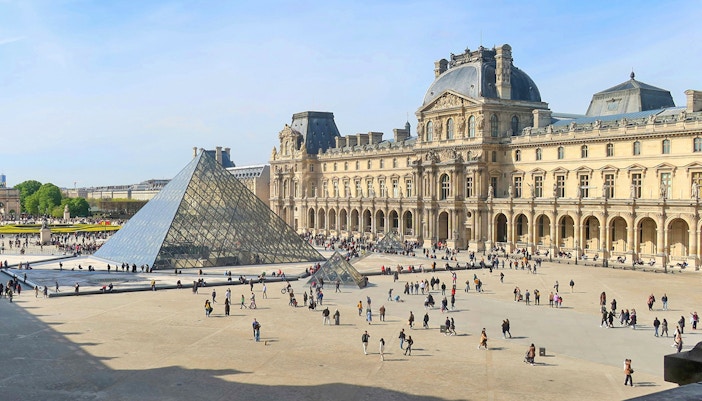 Visitors exploring art exhibits inside the Louvre Museum, Paris.