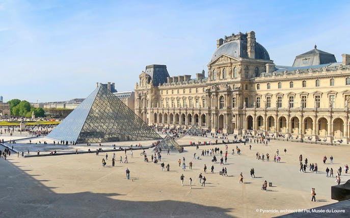 Louvre Museum courtyard with glass pyramid in Paris.