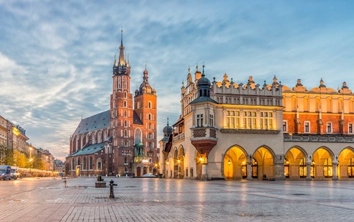 Krakow's Old Town with St. Mary's Basilica and Cloth Hall at dusk.