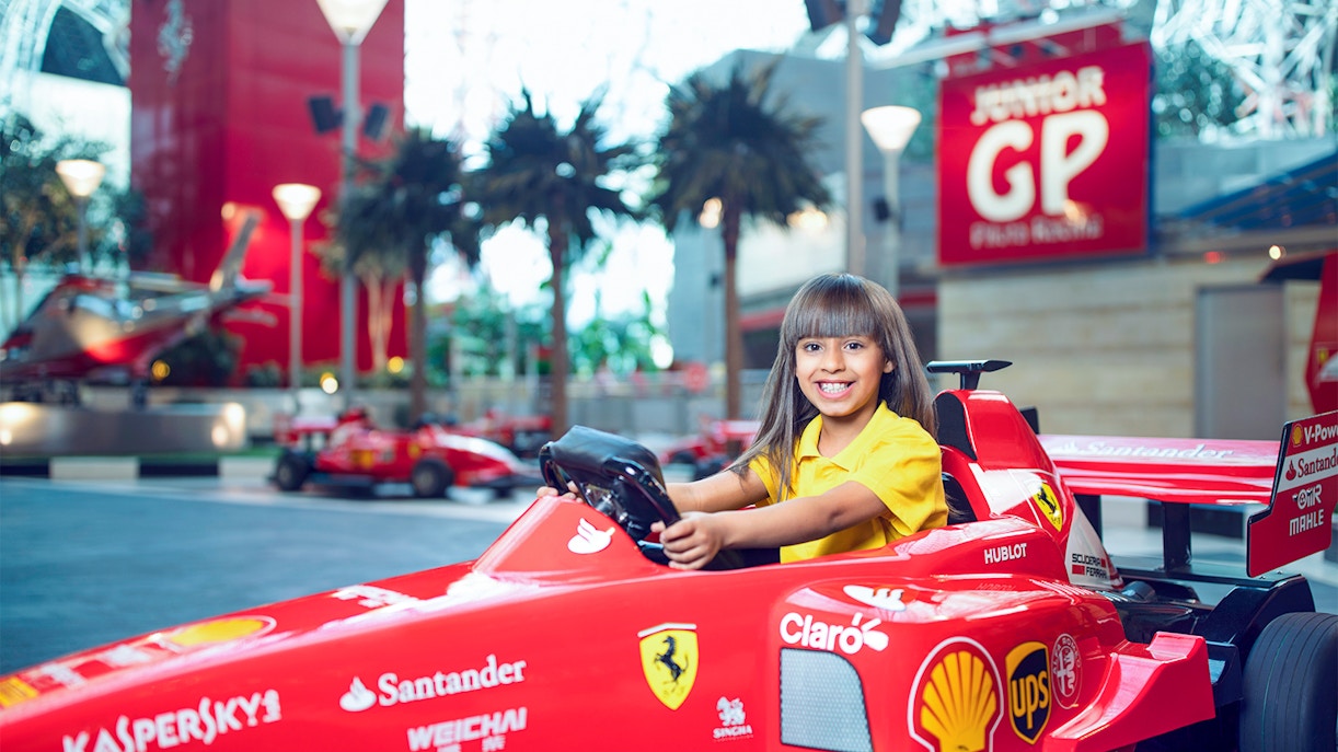 Girl driving toy car at Ferrari World