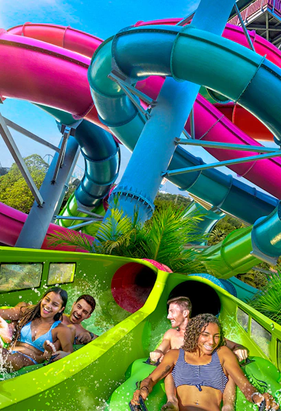 Visitors enjoying a colorful water slide at Aquatica Orlando.