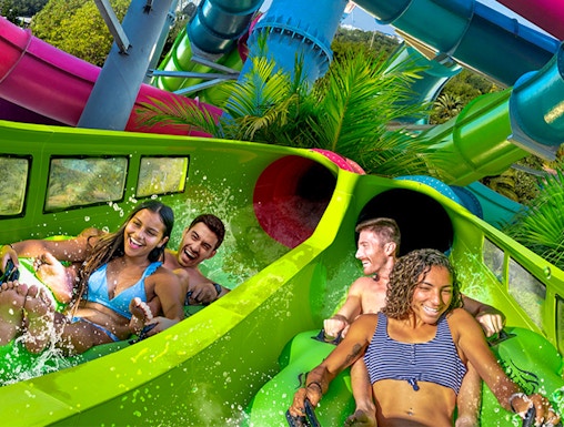 Visitors enjoying a colorful water slide at Aquatica Orlando.