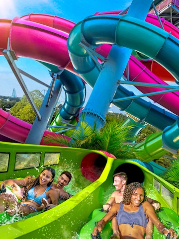 Visitors enjoying a colorful water slide at Aquatica Orlando.