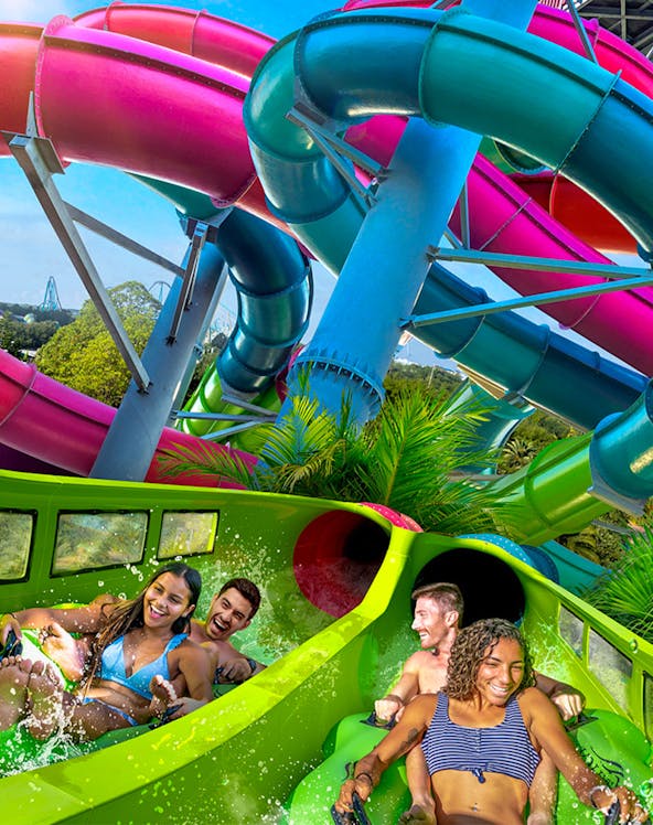 Visitors enjoying a colorful water slide at Aquatica Orlando.