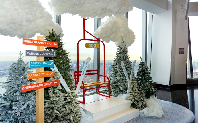 One World Observatory winter-themed display with directional signs and city view.