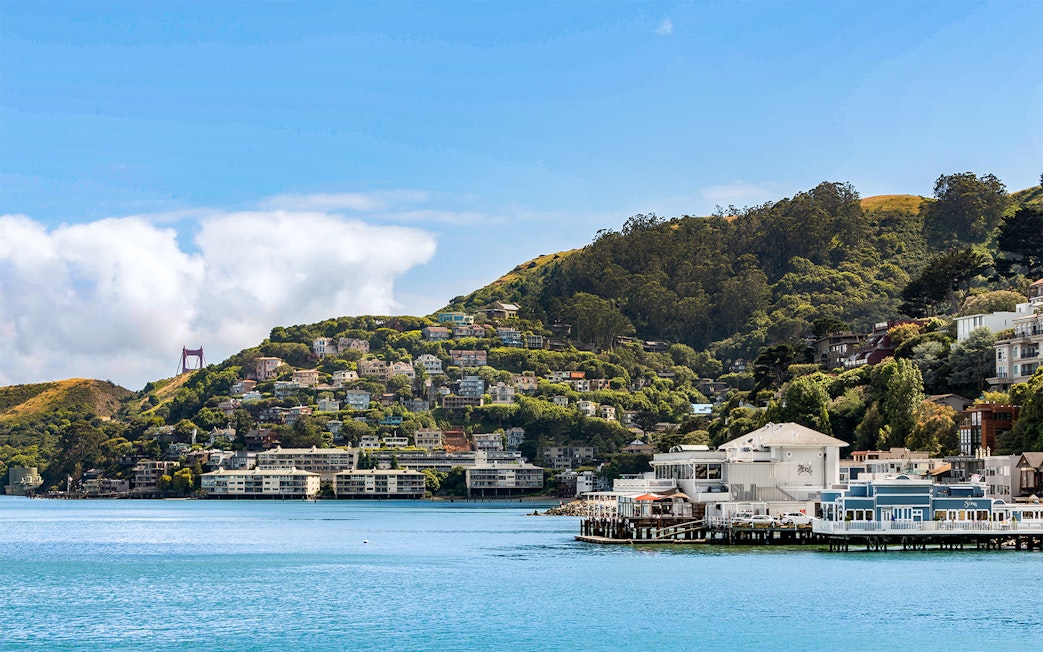 Sausalito Bay Area with hillside homes and partial view of Golden Gate Bridge, San Francisco, California.