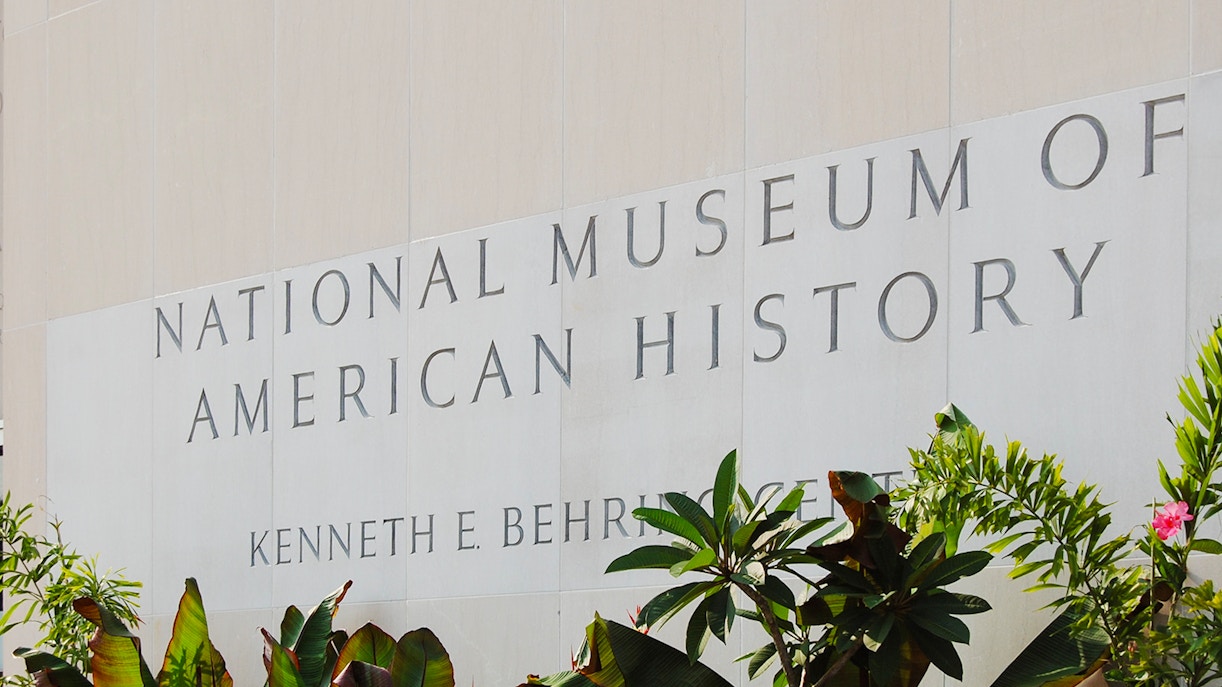 Smithsonian National Museum of American History entrance sign with plants.