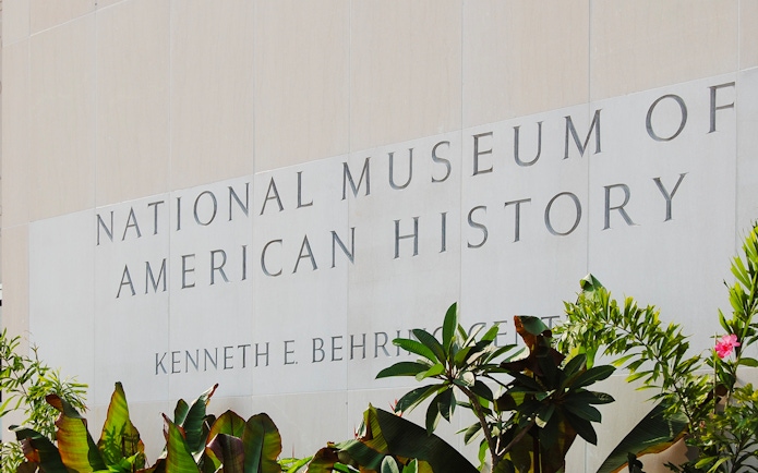 Smithsonian National Museum of American History entrance sign with plants.