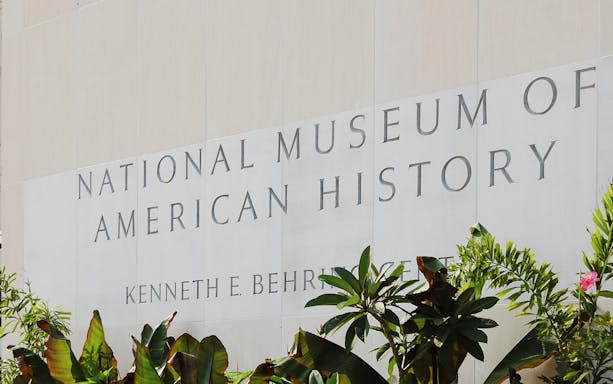 Smithsonian National Museum of American History entrance sign with plants.