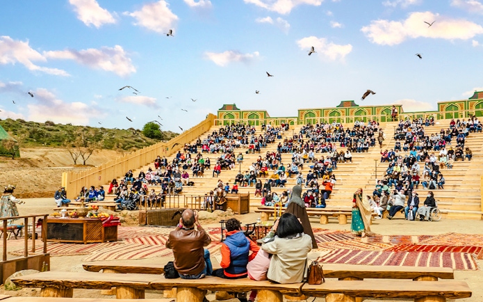 Audience watching an outdoor performance at Puy du Fou park show.