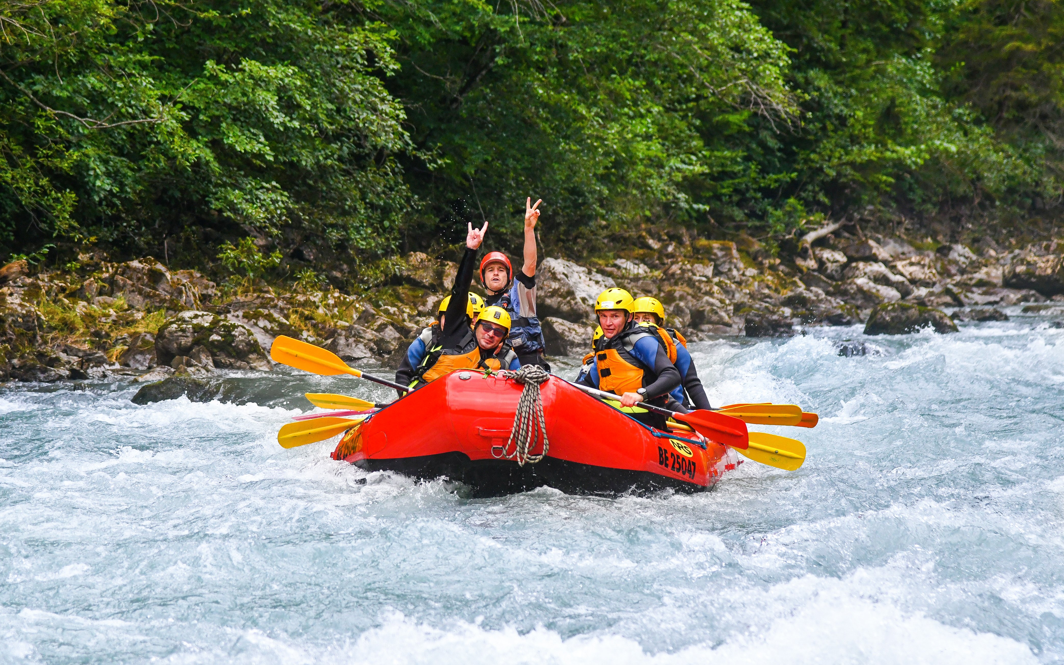 Rafting group navigating Lütschine River rapids in Switzerland.