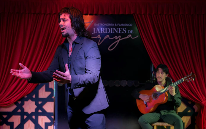 Flamenco singer performing with guitarist at Tablao Jardines de Zoraya.